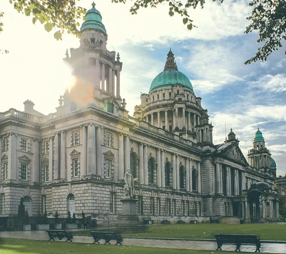 white and blue concrete building under white clouds and blue sky during daytime