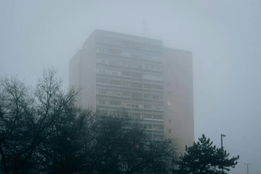 a very tall building in the middle of a foggy day