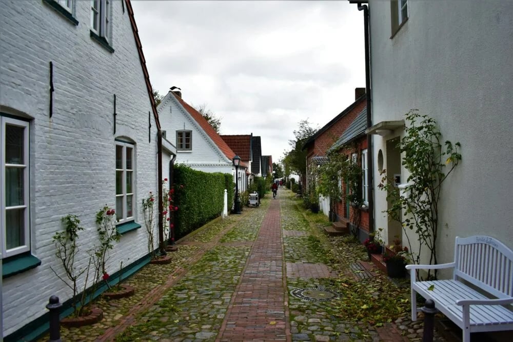 a white bench sitting on the side of a road