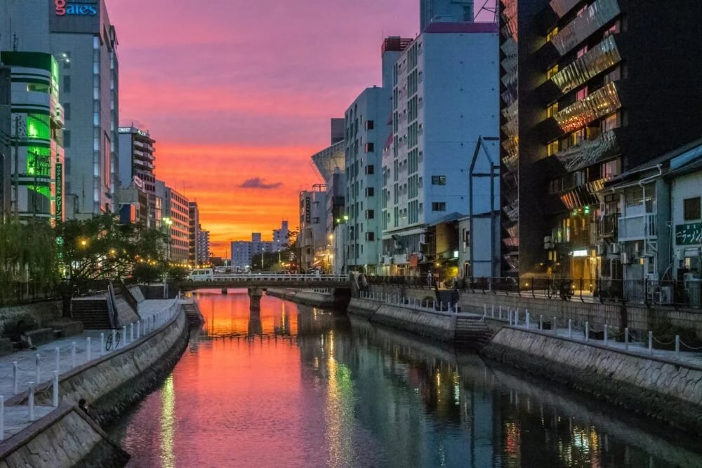 river between high rise buildings during night time