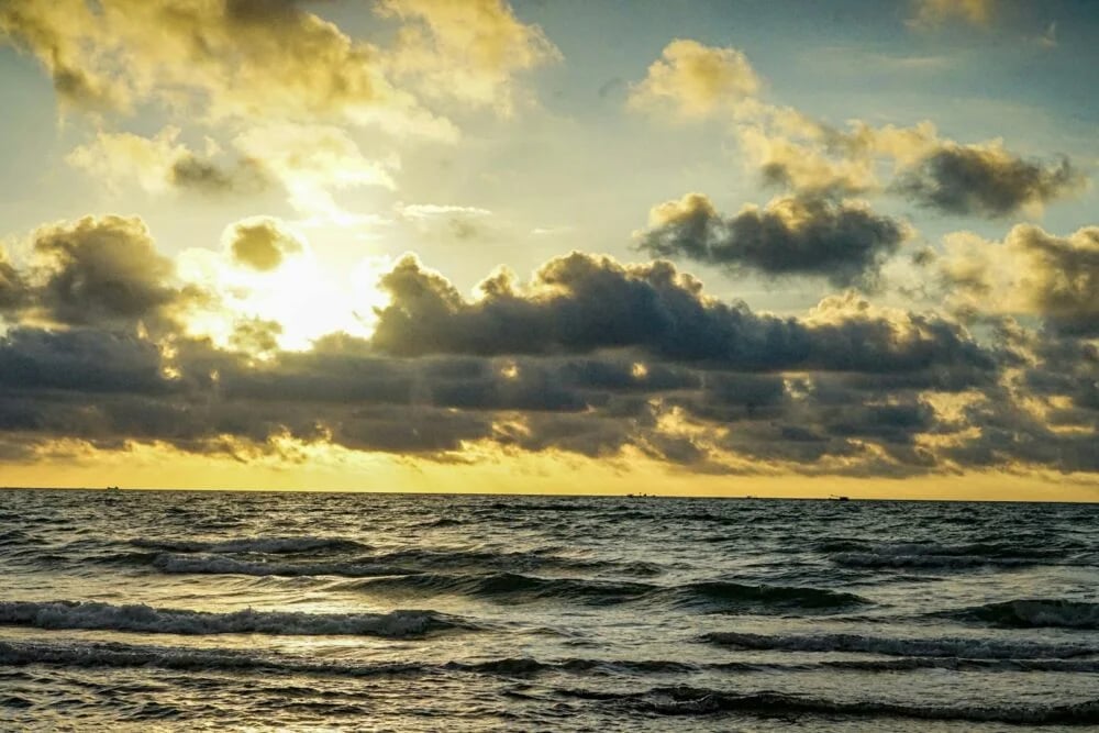 a large body of water under a cloudy sky