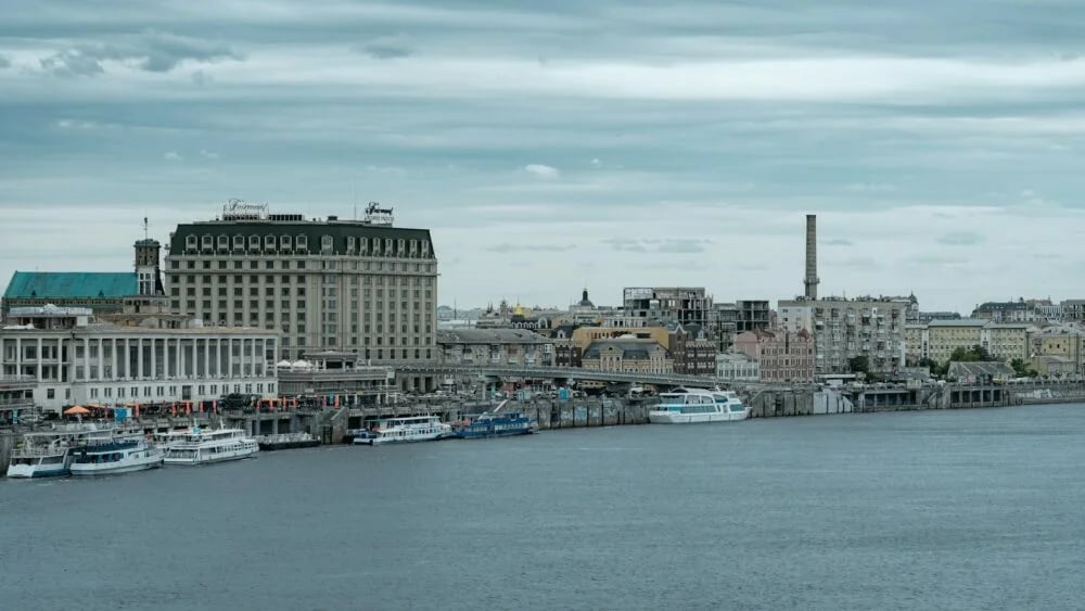white and blue boat on water near city buildings during daytime