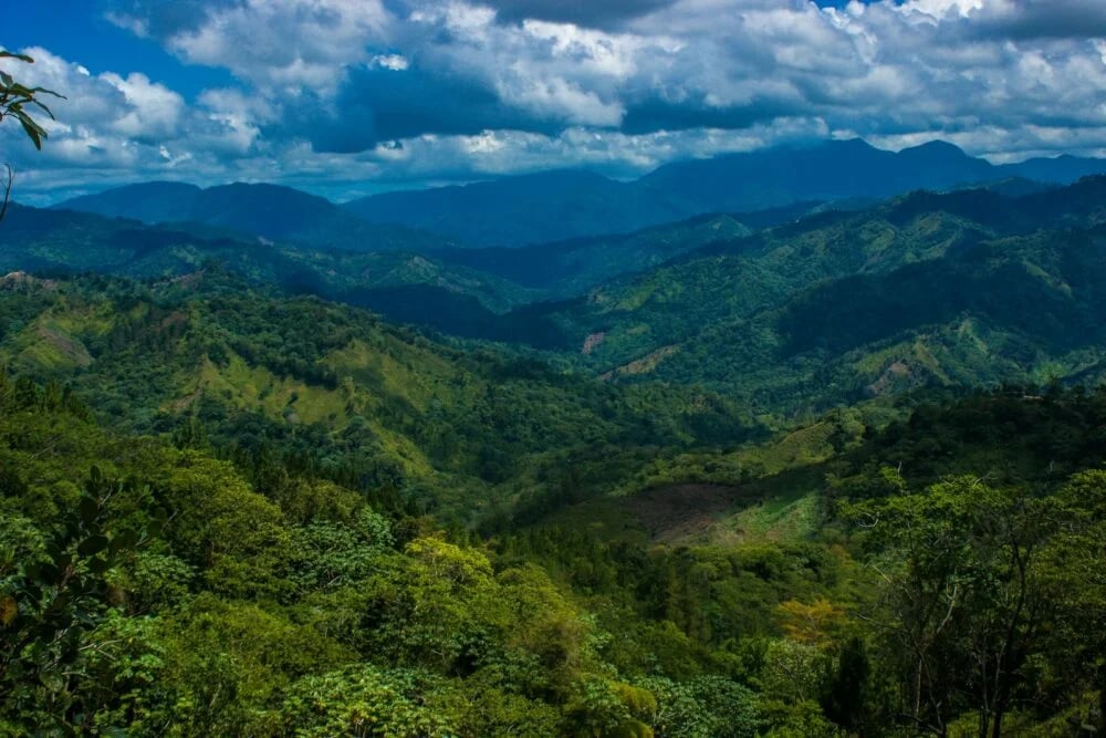 green mountains under blue sky and white clouds during daytime