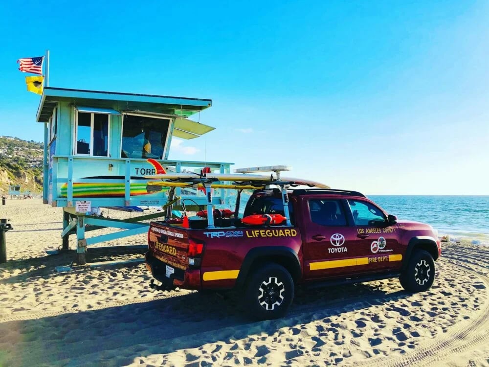 red suv parked near white and blue house during daytime