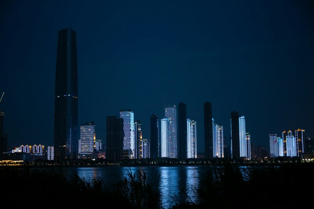 a city at night with a body of water in front of it