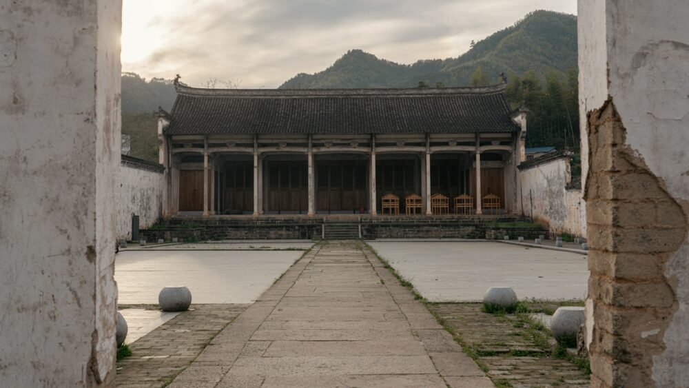 an open doorway leading to a building with mountains in the background